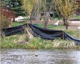 body of water with black tarp to contain runoff